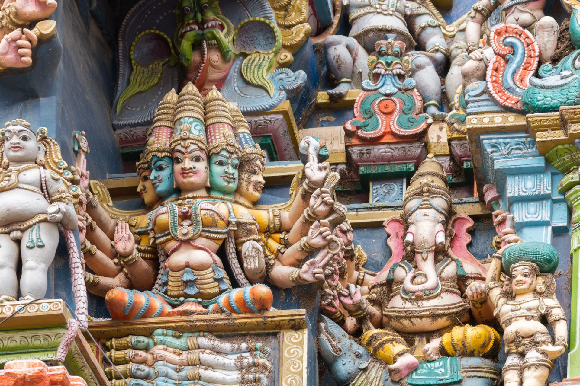 La déesse Gāyatrī assise sur un coffre contenant les quatre Vedas, accompagnée du dieu à tête d'éléphant Gaṇeśa (temple de Minakshi, Madurai, Tamil Nadu)